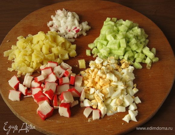 Нарезать яйца и картофель отварной кубиками, свежие огурцы и редис — мелкими кубиками, палочки крабовые — шайбочками.