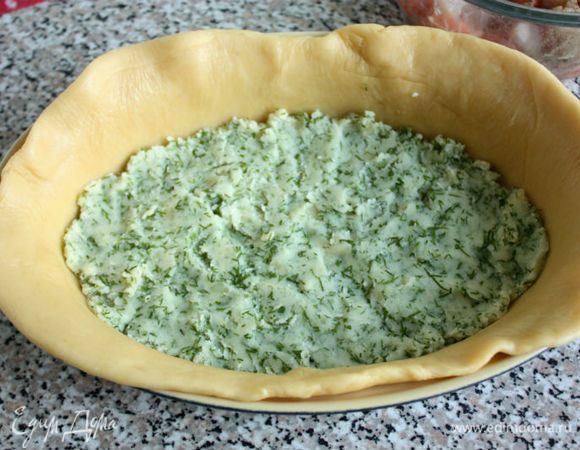 Тесто разделить на 2 неравные части, раскатать в пласты толщиной 5 мм. В форму для выпечки уложить большой пласт теста так, чтобы его края немного свисали. На тесто ровным слоем выложить картофельное пюре.
