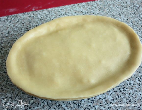 Смазать края теста слегка взбитым яйцом, накрыть форму вторым пластом и обрезать лишнее по размеру формы. Удобнее обрезать ножницами.