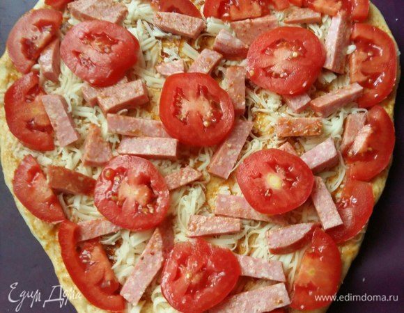 Затем выложить по всему краю помидор, нарезанный дольками. По центру выложить кружками.