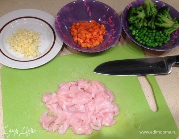 Подготовить остальные ингредиенты. Брокколи и горошек разморозить. Чеснок и имбирь мелко порубить. Морковь нарезать маленькими кубиками. Курицу нарезать тонкими полосками. Чем тоньше будут полоски, тем быстрее курица прожарится и успеет дать меньше сока. Нам нужно именно прожарить ее, а не сварить.