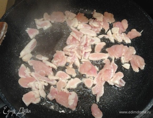 На очень большом огне разогреть сковороду. Налить кунжутное масло. Выложить кусочки курицы, поперчить и быстро обжарить (буквально пару минут), постоянно помешивая.