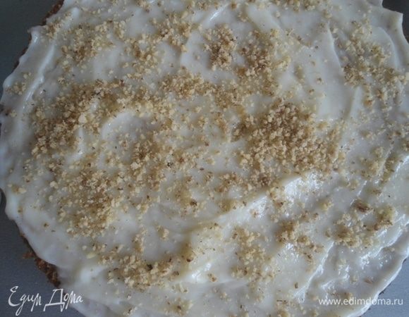 Сборка торта. Один корж смазать кремом, присыпать грецкими орехами. Накрыть вторым, снова смазать и украсить орехами по желанию.