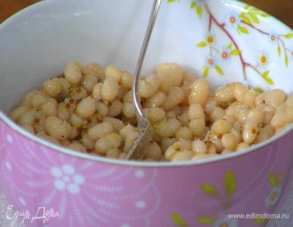 Отваренную белую фасоль полить половиной заправки, посолить и перемешать.