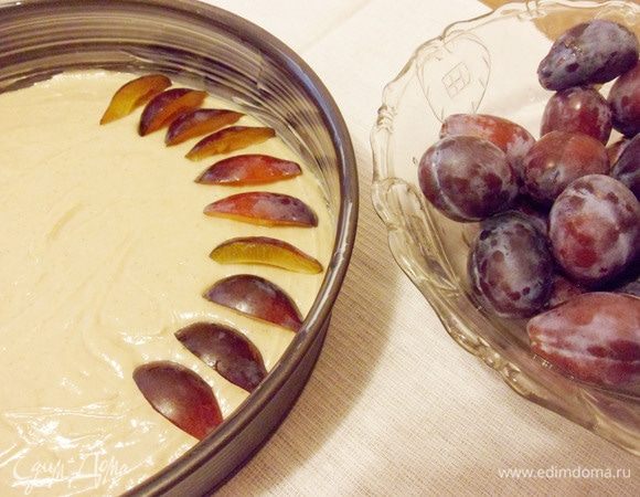 Сливы разрезать на четвертинки и разложить рядами по тесту.