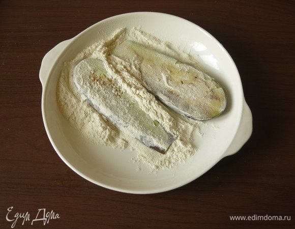 Пока тесто подходит, сливаем молоко, баклажаны обваливаем в муке.