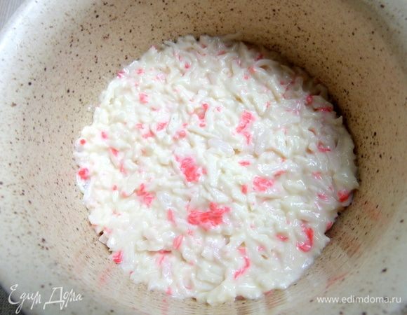 Итак, для сборки салата берем чашку (одна порция), смазываем растительным маслом и утрамбовываем на дно крабовые палочки плотно.