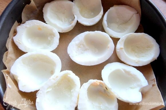 Разрезать яйца пополам, вынуть желтки и часть белка. Разложить на бумагу или фольгу в форме.