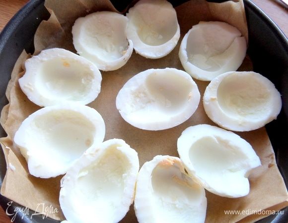 Разрезать яйца пополам, вынуть желтки и часть белка. Разложить на бумагу или фольгу в форме.