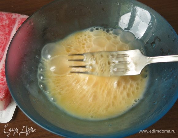 Пока варится рис, приготовим омлет с крабовыми палочками. Сбиваем 2 яйца с щепотками сахара и соли.