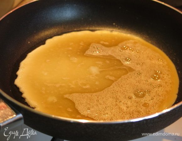 Выливаем половину яиц на сковородку с маслом. Даем омлету чуть схватится и кладем крабовые палочки.