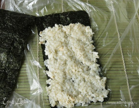 На нори выкладываем рис с яйцом, пару сантиметров от края не заполняем.