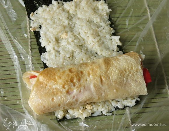 На край кладем рулет из омлета с крабовыми палочками.