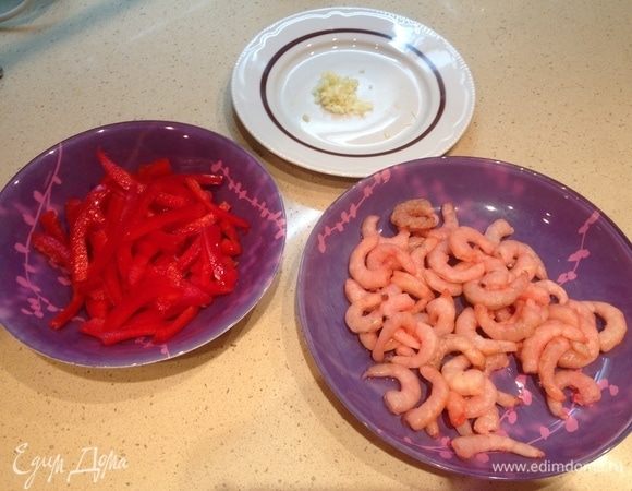 Подготовить ингредиенты. Креветки разморозить и слить всю жидкость. Чеснок мелко порубить. Перец нарезать тонкими небольшими полосками.