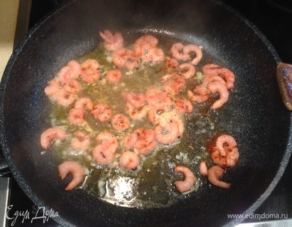 Почти сразу выложить креветки и слегка обжарить. Как следует поперчить и добавить зиру.