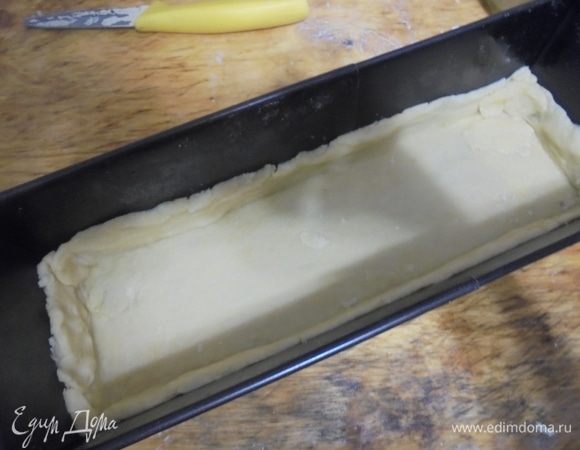 Тесто раскатать в продолговатый пласт и выложить в прямоугольную форму, смазанную маслом (у меня длиной 30 см), оформив невысокие бортики.