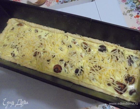 Сыр натереть на мелкой терке. Киш вынуть из духовки, посыпать натертым сыром и вернуть киш в духовку.