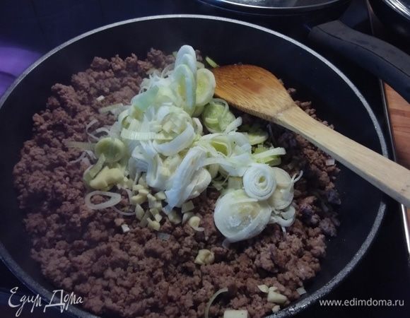 К фаршу добавить чеснок и порей. Обжарить в течение нескольких минут. 