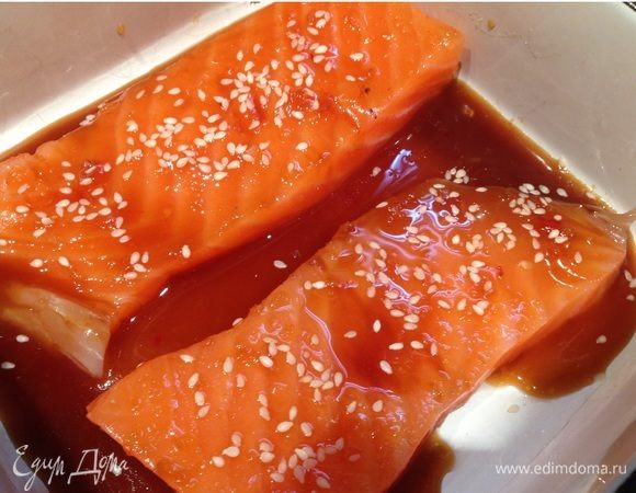 Лосось разрезать на порционные куски, выложить в жаропрочную посуду. Полить соусом, посыпать кунжутом. Запекать в духовке при 200°С 10–15 минут.