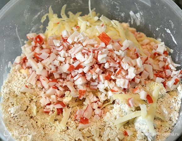 Масляно-мучную смесь перетереть в крошку руками. Добавить нарезанные крабовые палочки и натертый сыр.