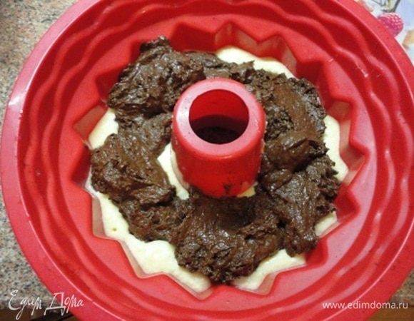 В смазанную маслом форму вылить светлое тесто, затем сверху выложить темное. Из-за какао порошка оно получается погуще. Это позволяет при выпечке оставаться ему внутри и быть «окутанным» светлым лимонным тестом.