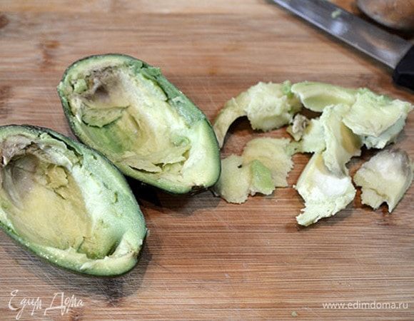 Авокадо разрезать пополам, мякоть выскрести и мелко нарезать.