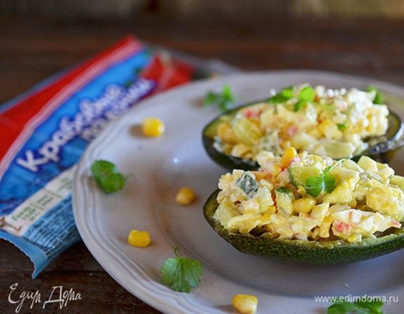 Все перемешайте, посолите, заправьте сметаной и выложите в половинки авокадо.