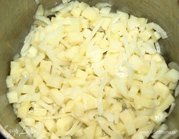 В глубокой посуде разогреть растительное масло и обжарить лук и картофель минуты 2–3.
