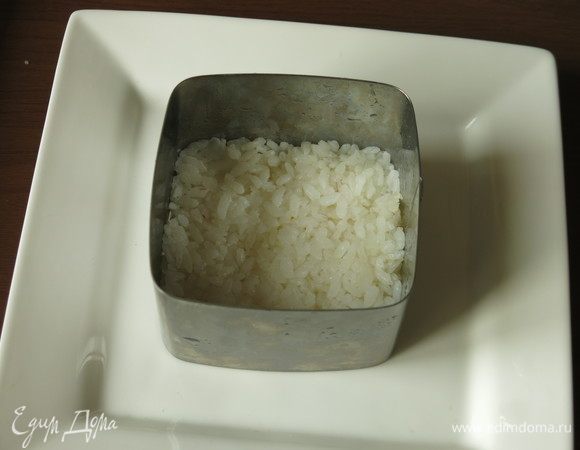 В квадратную форму (размер 8х8) утрамбовываем 55 г вареного заправленного риса, чуть смочив пальцы.
