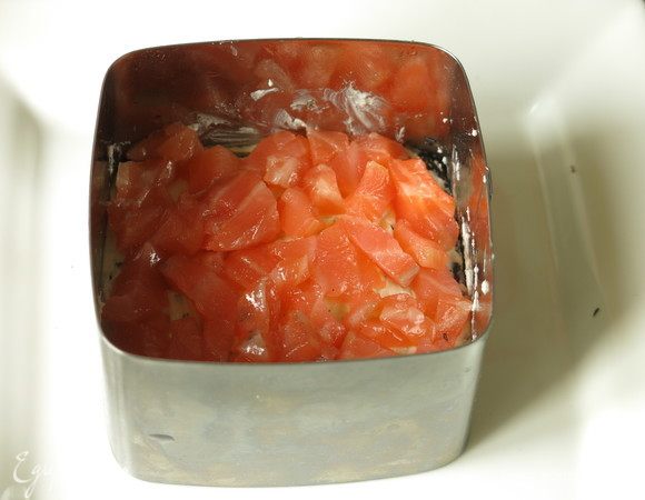 Сверху кусочки семги, сбрызгиваем соевым соусом. Утрамбовываем.