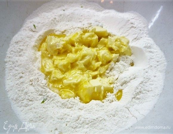 Добавляем мягкое сливочное масло и перемешиваем его с мукой.