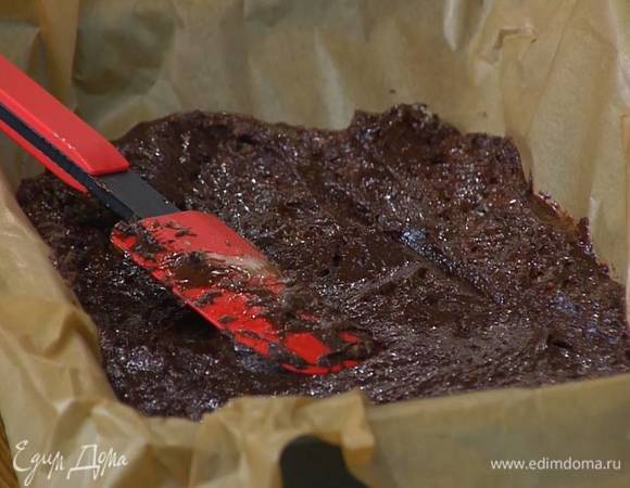 Небольшой глубокий противень выстелить бумагой для выпечки, выложить тесто и разровнять его.