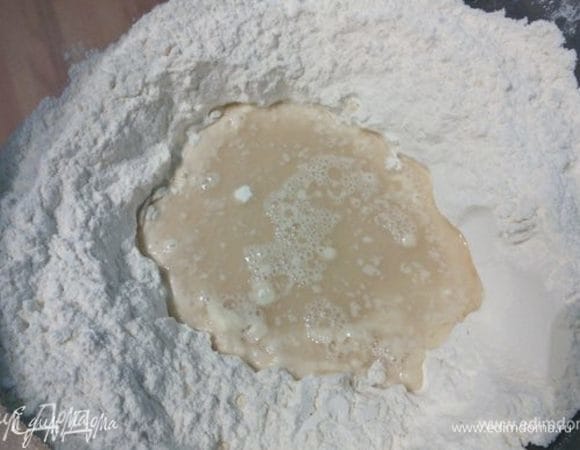 Для теста просеять муку в чашу комбайна, в середине сделать лунку.  Дрожжи и мед развести в половине количества воды комнатной температуры, влить в лунку и оставить на 15 минут.