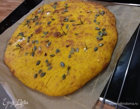 Распределить веточки розмарина, кусочки перца чили и тыквенные семечки. Противень (пустой!) поместить в самый нижний уровень духовки и включить ее на самую большую температуру (у меня 250°С) на разогрев. Достать горячий противень, выложить на него пергамент с фокаччей, выпекать на нижнем ярусе духовки 10 мин, затем переместить противень в середину духовки, уменьшить температуру до 200°С и печь еще 10-15 минут. Готовность рекомендую проверить на сухую палочку. 