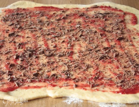 Малину заранее протрите с сахаром, а также натрите шоколад. Смажьте малиной тесто, присыпьте шоколадной стружкой и аккуратно скатайте в рулет. 