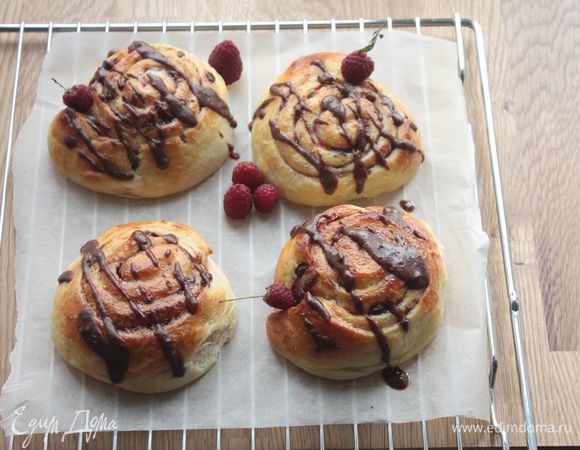 Готовым булочкам дайте немного остыть под полотенцем в течение получаса после готовки, затем полейте шоколадным соусом (растопите сливочное масло вместе с шоколадом) и украсьте свежей малиной. Приятного аппетита!