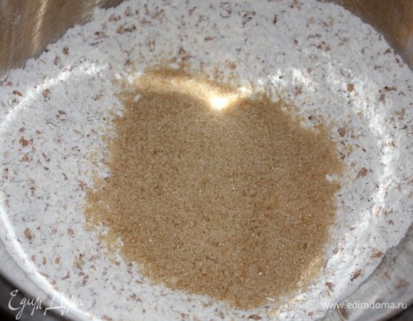 В миску с мукой и сыпучими ингредиентами добавить гречневые хлопья и остатки тростникового сахара. Все перемешать.