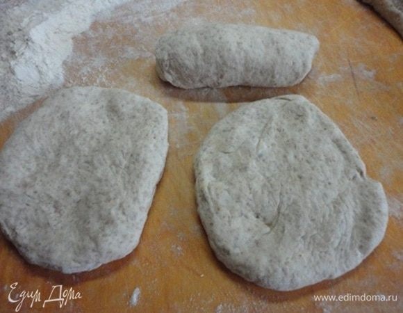 Некрупные изделия из дрожжевого теста я избегаю раскатывать скалкой, а просто «раскатываю» руками овальные лепешечки. Закатываем, формируя продолговатые булочки. Выкладываем на лист и даем подняться.