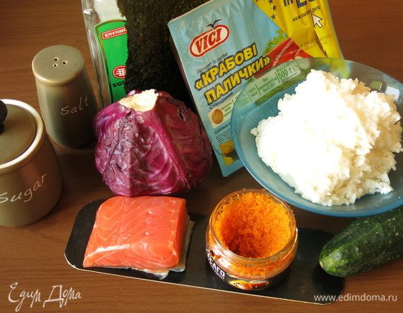 Подготовим рис, крабовые палочки VICI, икру, красную рыбу, огурец, компоненты для заправки риса. Рис промываем, выдерживаем в воде час, сливаем воду, просушиваем рис, варим в 250 мл воды с момента закипания 10 минут под крышкой, даем еще постоять 10 минут под крышкой, заправляем, аккуратно перемешивая и обмахивая веером.