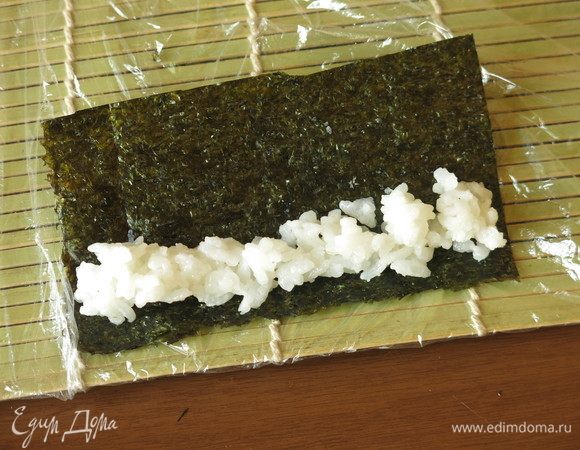 12 г белого риса заворачиваем в нори — ширина равна длине палочки, длина листа — 1/6 от длины листа нори.