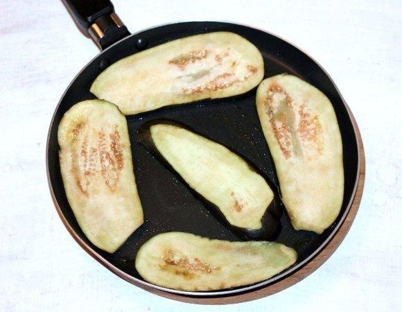 Разогреваем на сковороде растительное масло и обжариваем пластины баклажана.