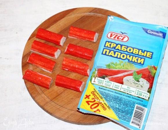 Берем из упаковки 4 крабовые палочки и разрезаем каждую пополам.
