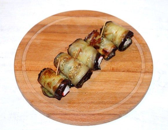 Заворачиваем пластину баклажана в рулетик, закрепляем зубочисткой. Начинка готова!
