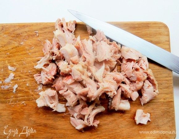 Готовим куриную начинку. Куриные голени отвариваем в воде минут 30–40 с добавлением лука, черного душистого перца горошком, лаврового листа и соли. Даем полностью остыть в сваренном бульоне, это делает мясо более сочным. Отделяем мякоть от костей и нарезаем мелкими кубиками.
