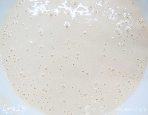 Спустя 10 минут добавить 100 мл горячей воды, снова взбить на малой скорости миксера. Добавляем оливковое масло и вручную вымешиваем венчиком до однородности.