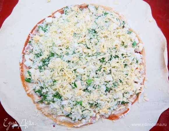 Сверху выкладываем равномерно половину рисово-яичной начинки, присыпаем тертым сыром.