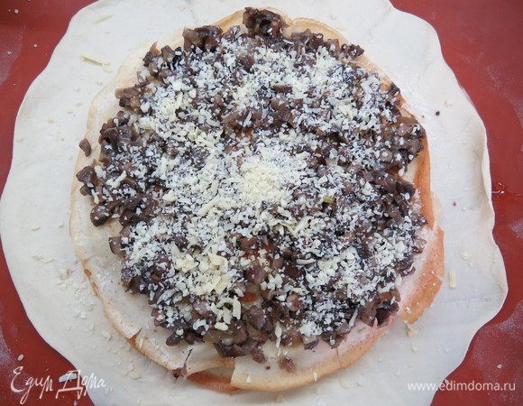 Накрываем третьим блинчиком (его мы смазывать сметанной заправкой не будем, так как грибная начинка не такая сухая, как первые две), на блинчик выкладываем половину грибной начинки, сверху опять присыпаем немного тертым сыром. Снова накрываем блинчиком и все повторяем в той же последовательности, при этом немного прижимая руками каждый слой. Последним слоем у нас будет блинчик (его смазывать сметанной заправкой не нужно).

