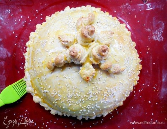 Через полчаса достаем наш курник и смазываем наш пирог желтковой смесью, присыпаем семенами кунжута. Ставим в духовку еще на 10 минут.

