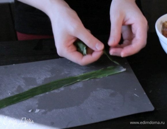 На край пера положить листочек мяты, сверху листочек кинзы.