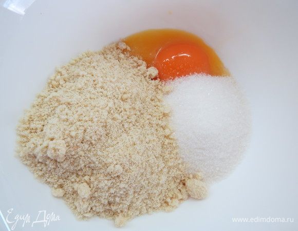 Очищенные орехи смолоть в муку в кофемолке. Соединить ореховую муку, желтки и 100 г сахара.